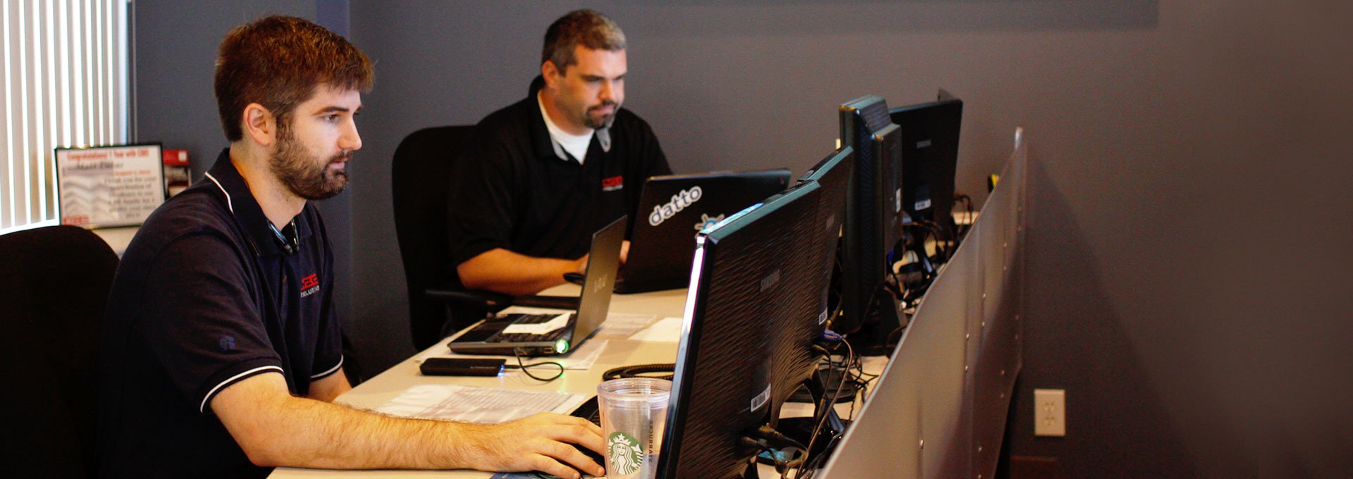 Two Carolina Business Equipment service representatives on their computers
